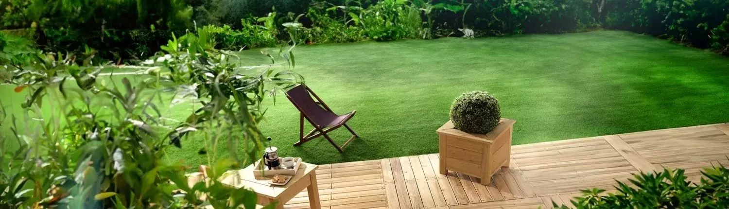 jardin avec une terrasse bois en lames de robinier bordée par un gazon